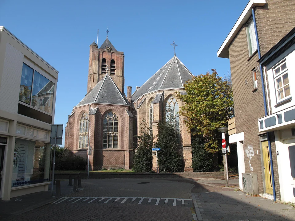 De Grote Kerk met bakstenen gevels en straat in het centrum van Monster